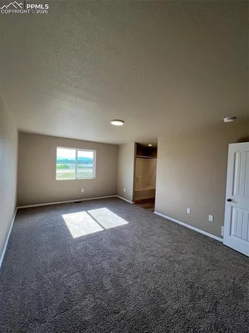 an empty room with windows and entrance stairs