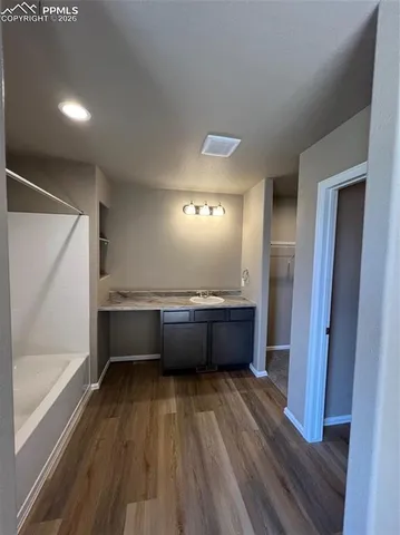 a bathroom with a tub sink and mirror
