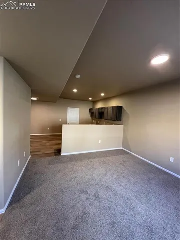 a view of an empty room with a kitchen