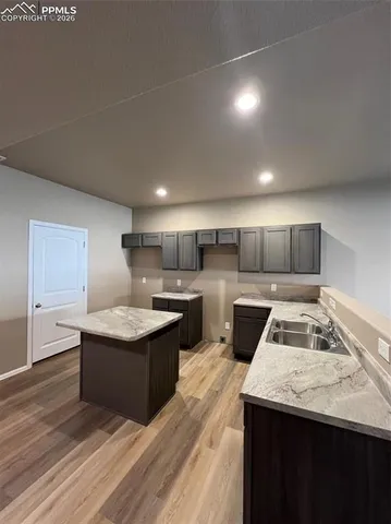 a kitchen with stainless steel appliances granite countertop a sink a stove and a wooden floors