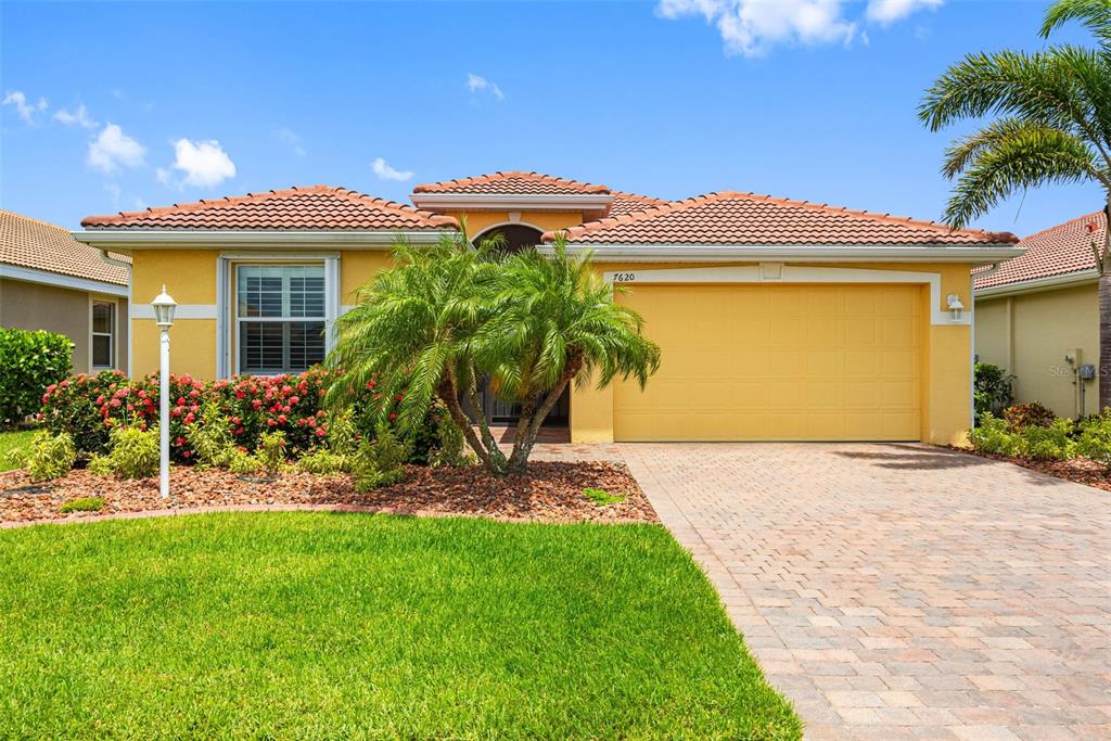 a front view of a house with a garden and yard