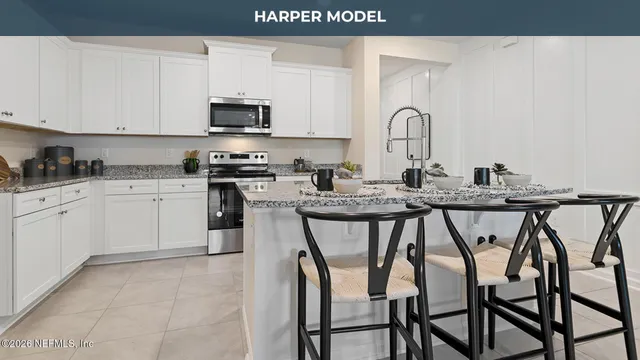 a kitchen with granite countertop white cabinets and stainless steel appliances