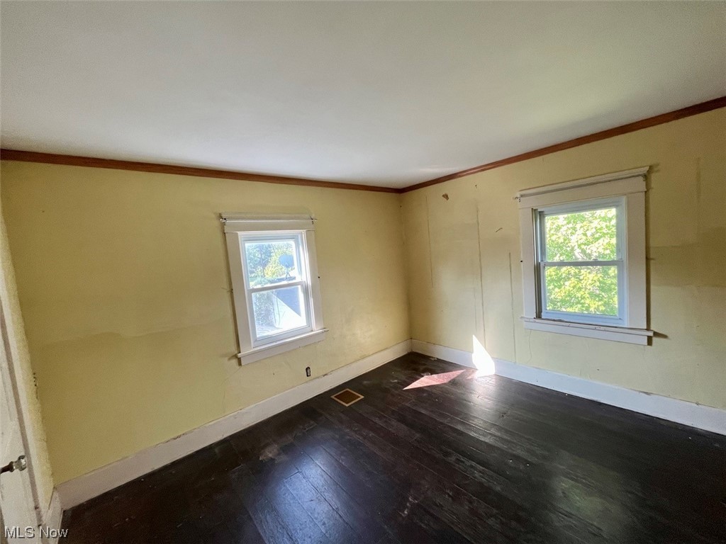16485 Mock Road Berlin Center, OH 44401 - Photo 25 of 30 Empty room featuring dark hardwood flooring and crown molding