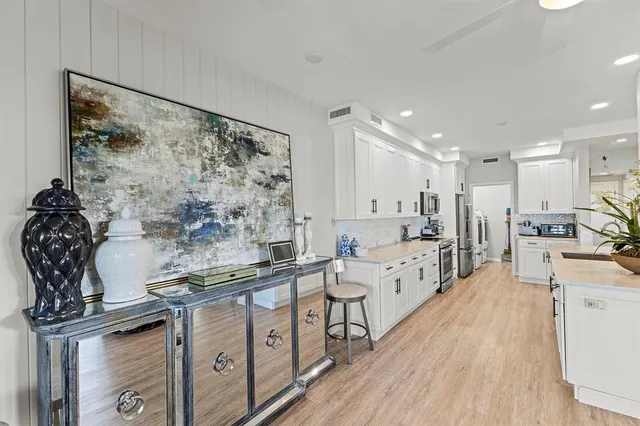 a kitchen with appliances a sink and cabinets