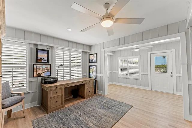 a room with lots of wooden furniture and windows
