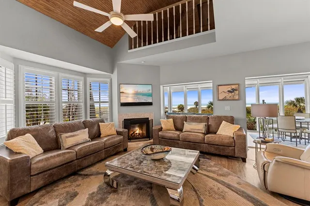 a living room with furniture fireplace and a large window