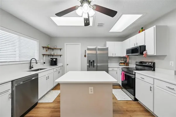 a kitchen with stainless steel appliances a sink stove refrigerator and cabinets
