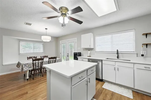 a kitchen with a table chairs sink and cabinets