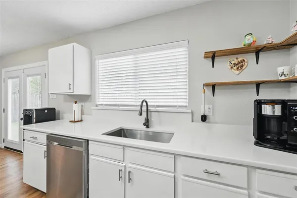 a kitchen with appliances a sink and cabinets