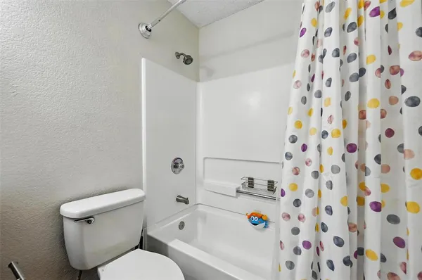 a white toilet sitting next to a shower curtain