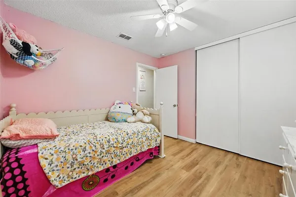 a bedroom with a bed and a chandelier fan