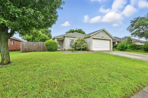 a view of a house with a yard and large tree