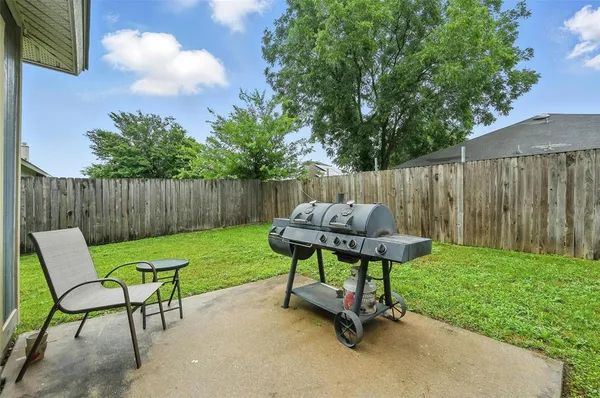 a view of a backyard with chairs and a garden