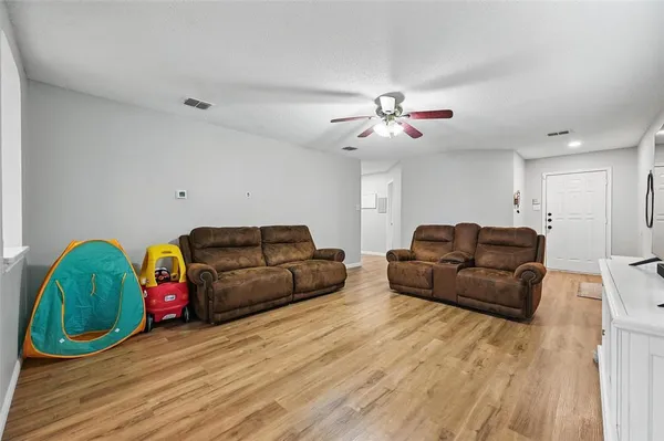 a living room with furniture and wooden floor