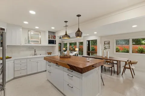 a kitchen with center island table and chairs