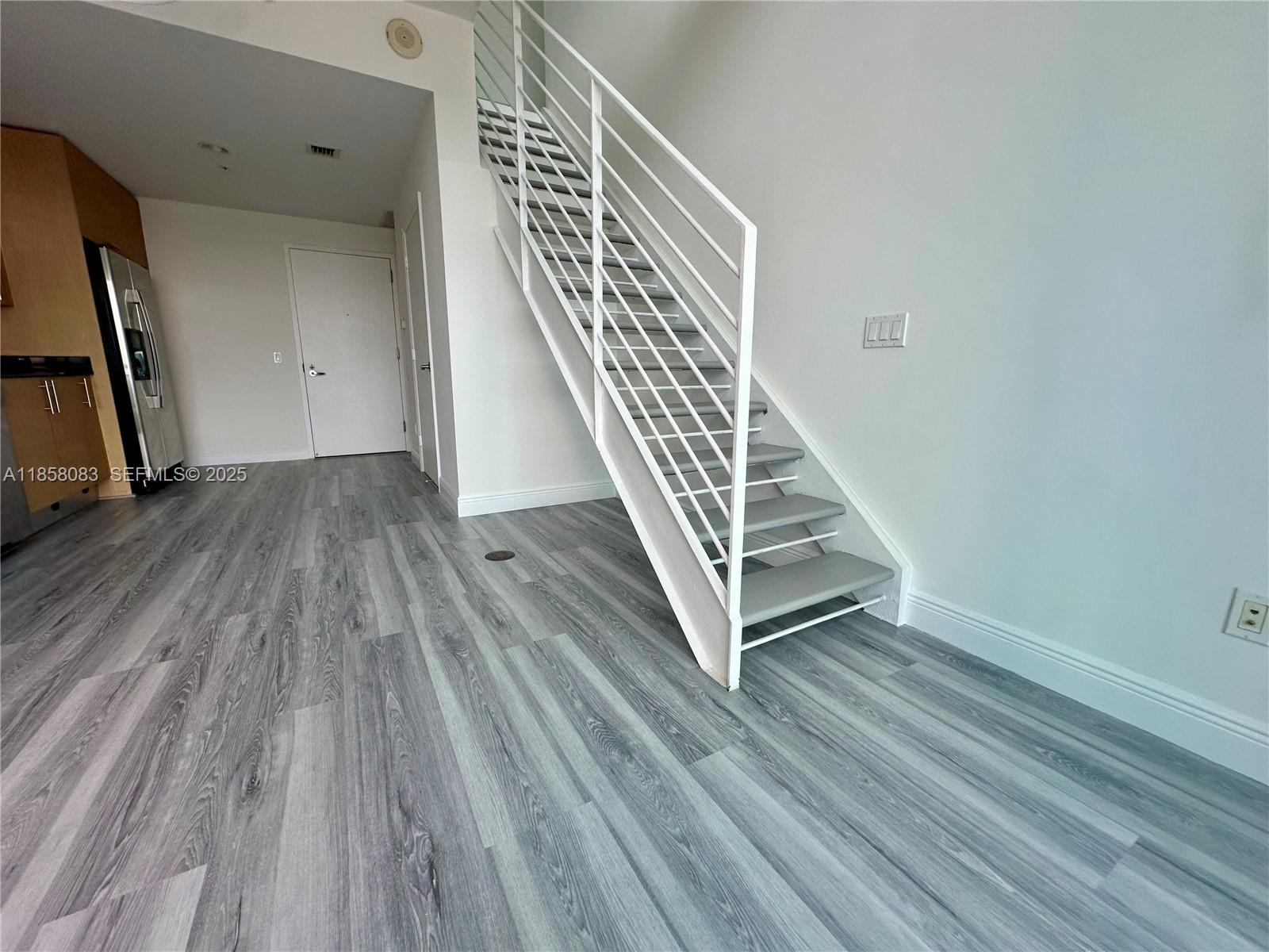 60 Southwest 13th Street, Unit 3207 Miami, FL 33130 - Photo 11 of 30 a view of a hallway with wooden floor and staircase