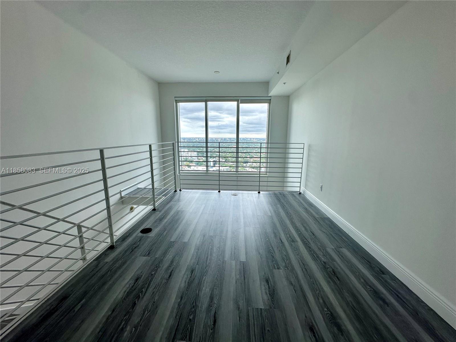 60 Southwest 13th Street, Unit 3207 Miami, FL 33130 - Photo 13 of 30 a view of empty room with wooden floor and fan