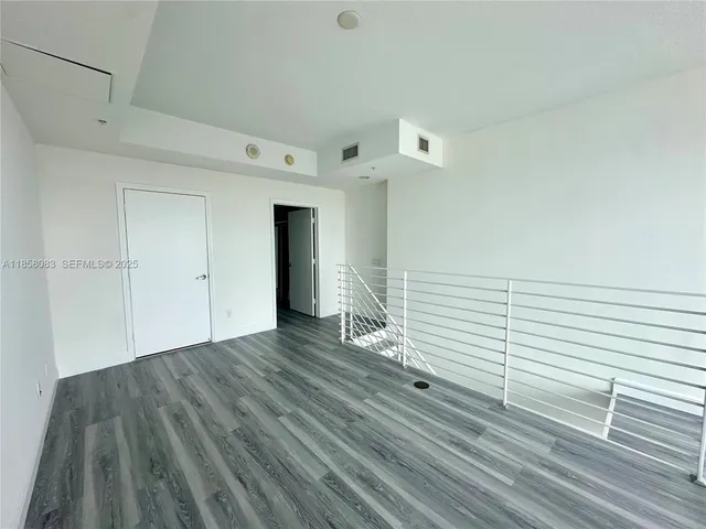 a view of a room with wooden floor and white walls