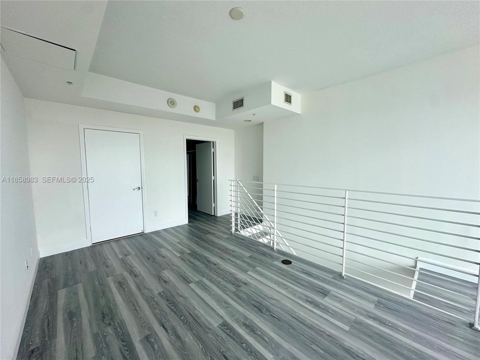 60 Southwest 13th Street, Unit 3207 Miami, FL 33130 - Photo 15 of 30 a view of a room with wooden floor and white walls