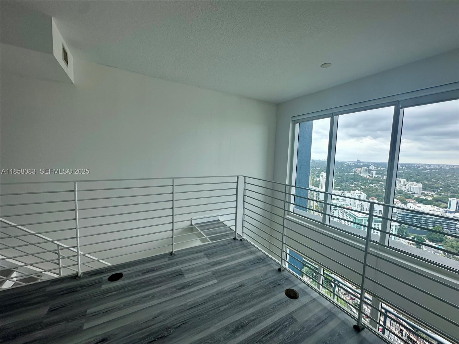 60 Southwest 13th Street, Unit 3207 Miami, FL 33130 - Photo 17 of 30 a view of a balcony with floor to ceiling windows with wooden floor