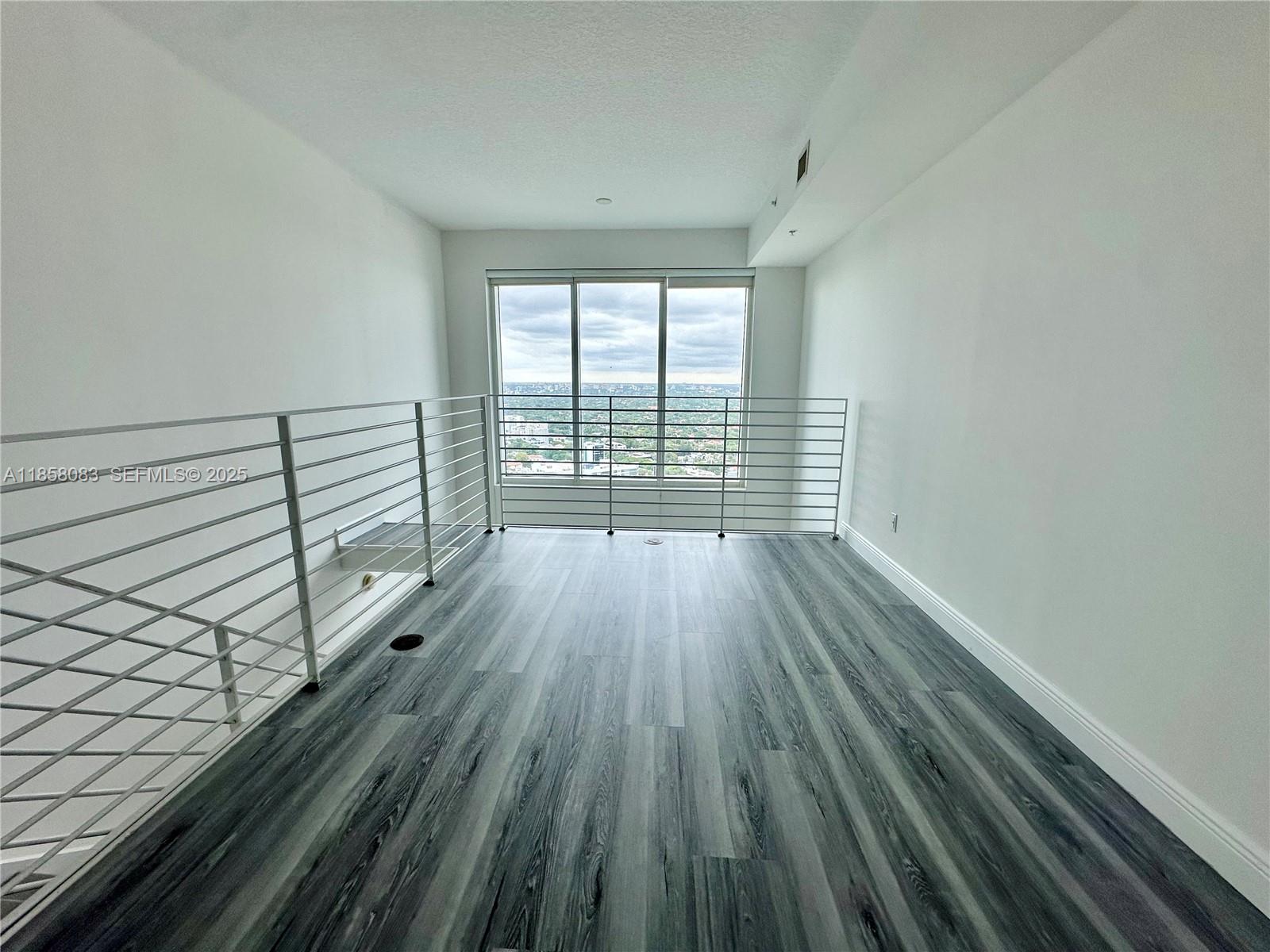 60 Southwest 13th Street, Unit 3207 Miami, FL 33130 - Photo 19 of 30 an empty room with wooden floor and windows