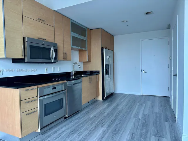 a kitchen with wooden floors and wooden cabinets