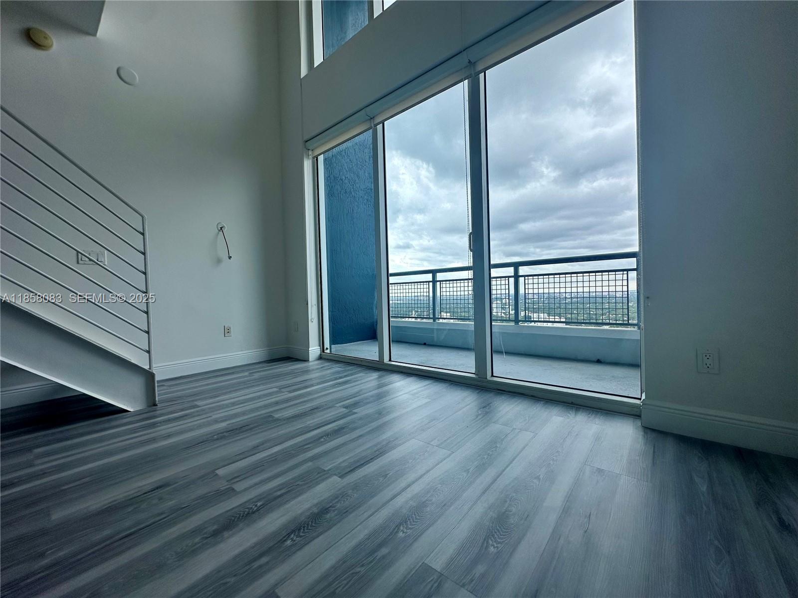 60 Southwest 13th Street, Unit 3207 Miami, FL 33130 - Photo 9 of 30 an empty room with wooden floor and windows
