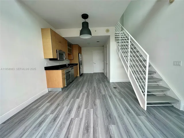 a kitchen with a sink and wooden floor