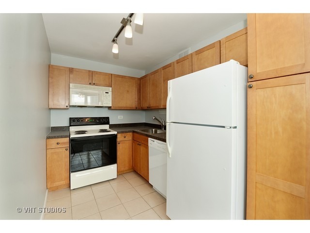 655 West Irving Park Road, Unit 1515 Chicago, IL 60613 - Photo 3 of 10 a kitchen with stainless steel appliances a refrigerator sink and stove