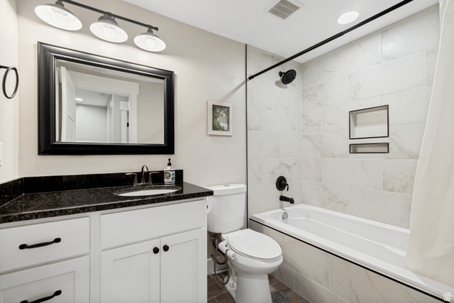 332 South 500 West Payson, UT 84651 - Photo 50 of 50 Bathroom featuring a white vanity with dark countertop, large framed mirror, and a white tub with tiled surround and built-in niches