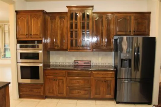 a kitchen with stainless steel appliances granite countertop a refrigerator and a stove