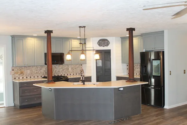 a large kitchen with stainless steel appliances kitchen island granite countertop a refrigerator and a stove