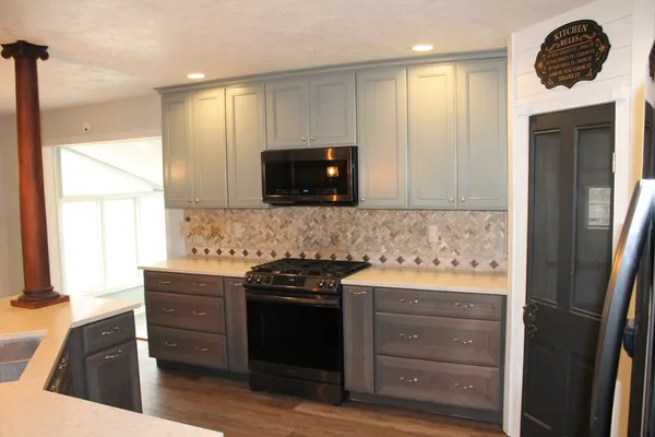 a kitchen with granite countertop a stove and a wooden cabinets