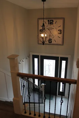 a view of a hallway with windows and chandelier