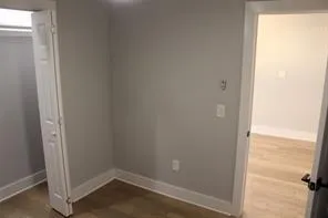 an empty room with wooden floor and entrance