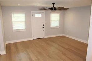 an empty room with a window and a ceiling fan