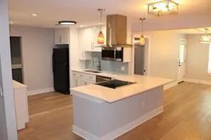 a kitchen with stainless steel appliances granite countertop a sink and a refrigerator
