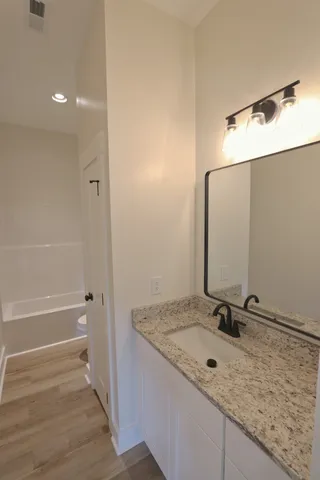 a bathroom with a granite countertop sink and a mirror