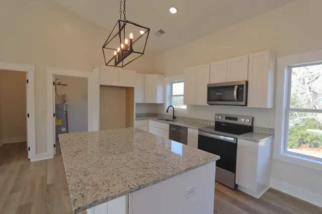 a kitchen with stainless steel appliances granite countertop a sink refrigerator and microwave