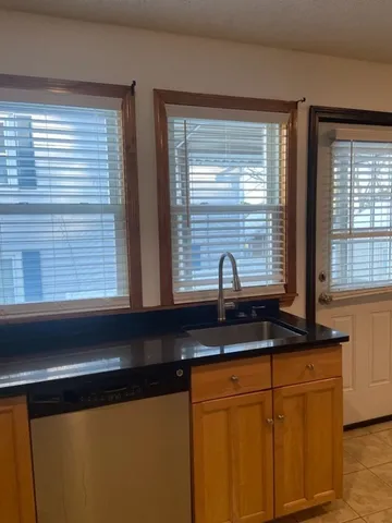a kitchen with granite countertop cabinets sink and window