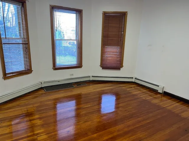 a view of a room with wooden floor and window