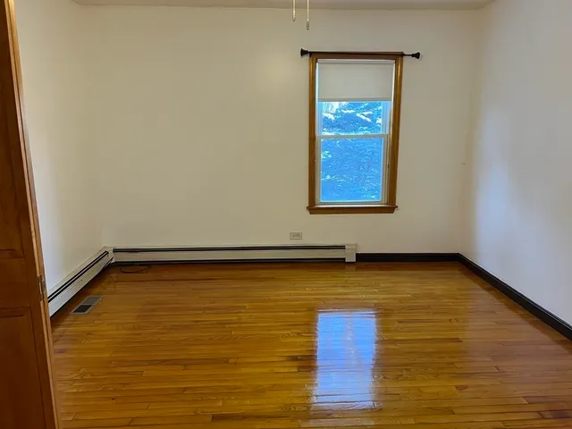a view of a room with wooden floor and window