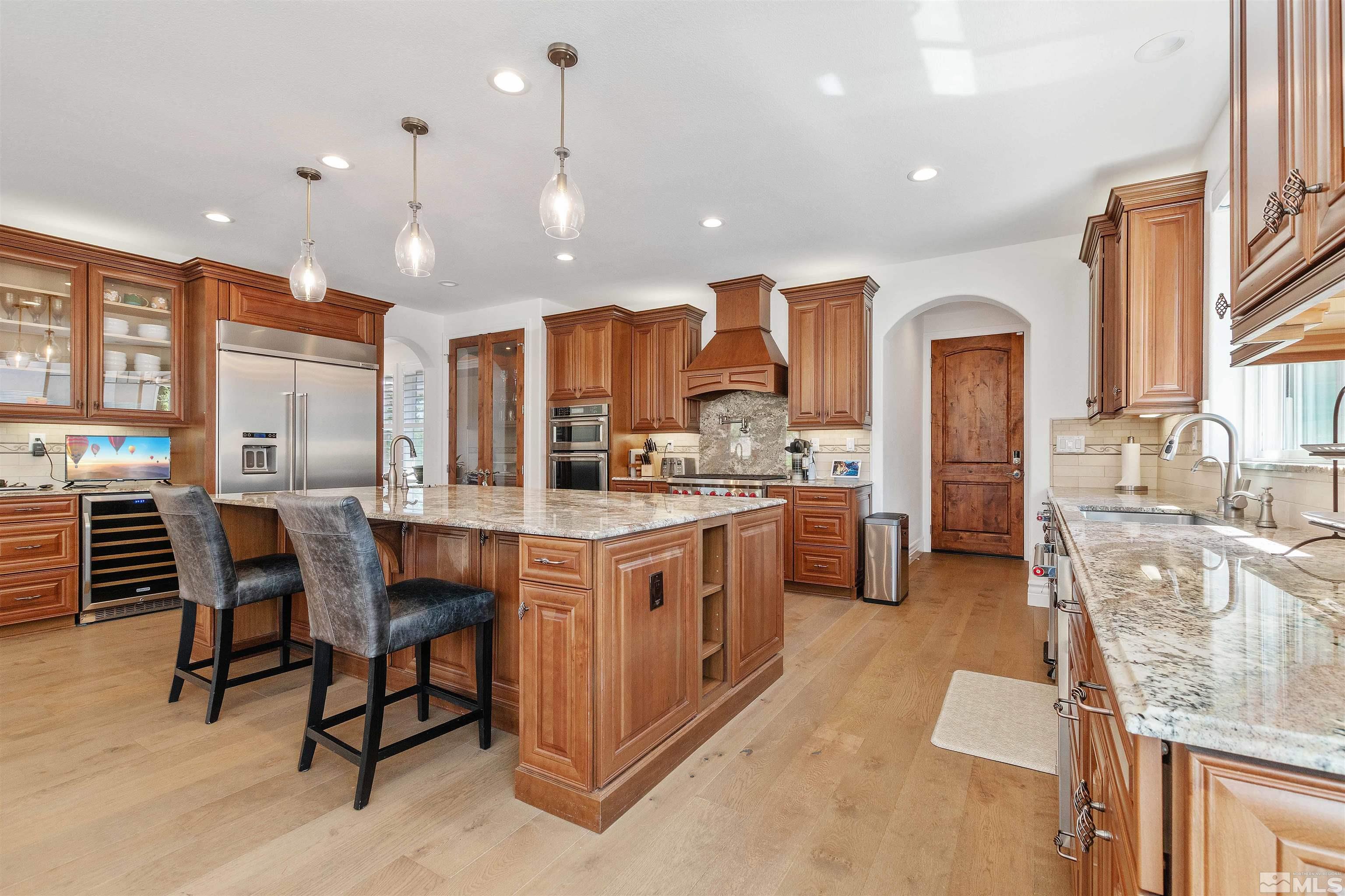 12825 Silver Wolf Road Reno, NV 89511 - Photo 11 of 34 a kitchen with kitchen island granite countertop lots of counter top space and stainless steel appliances