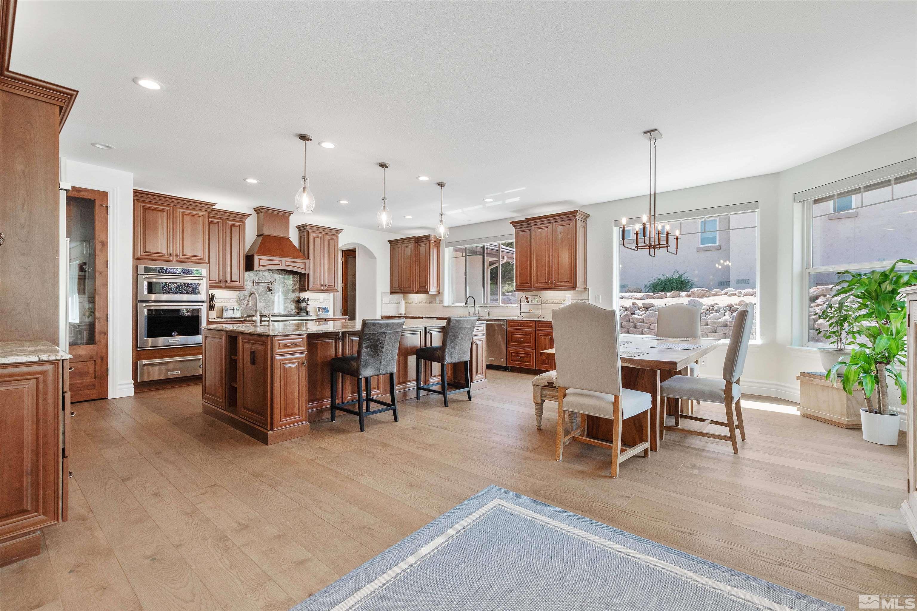 12825 Silver Wolf Road Reno, NV 89511 - Photo 13 of 34 a living room with stainless steel appliances kitchen island granite countertop furniture wooden floor and a kitchen view