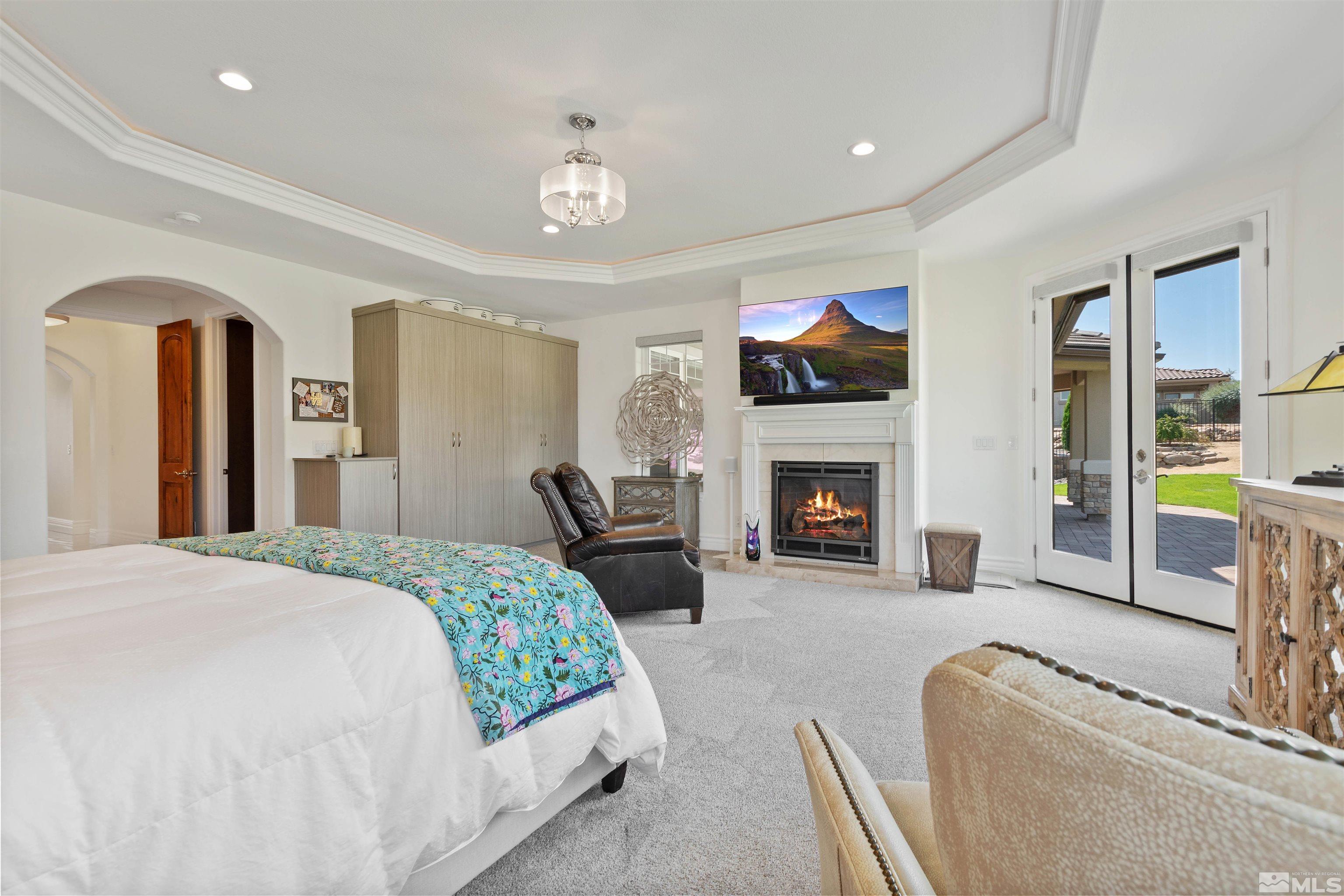 12825 Silver Wolf Road Reno, NV 89511 - Photo 22 of 34 a spacious bedroom with a bed and a fireplace