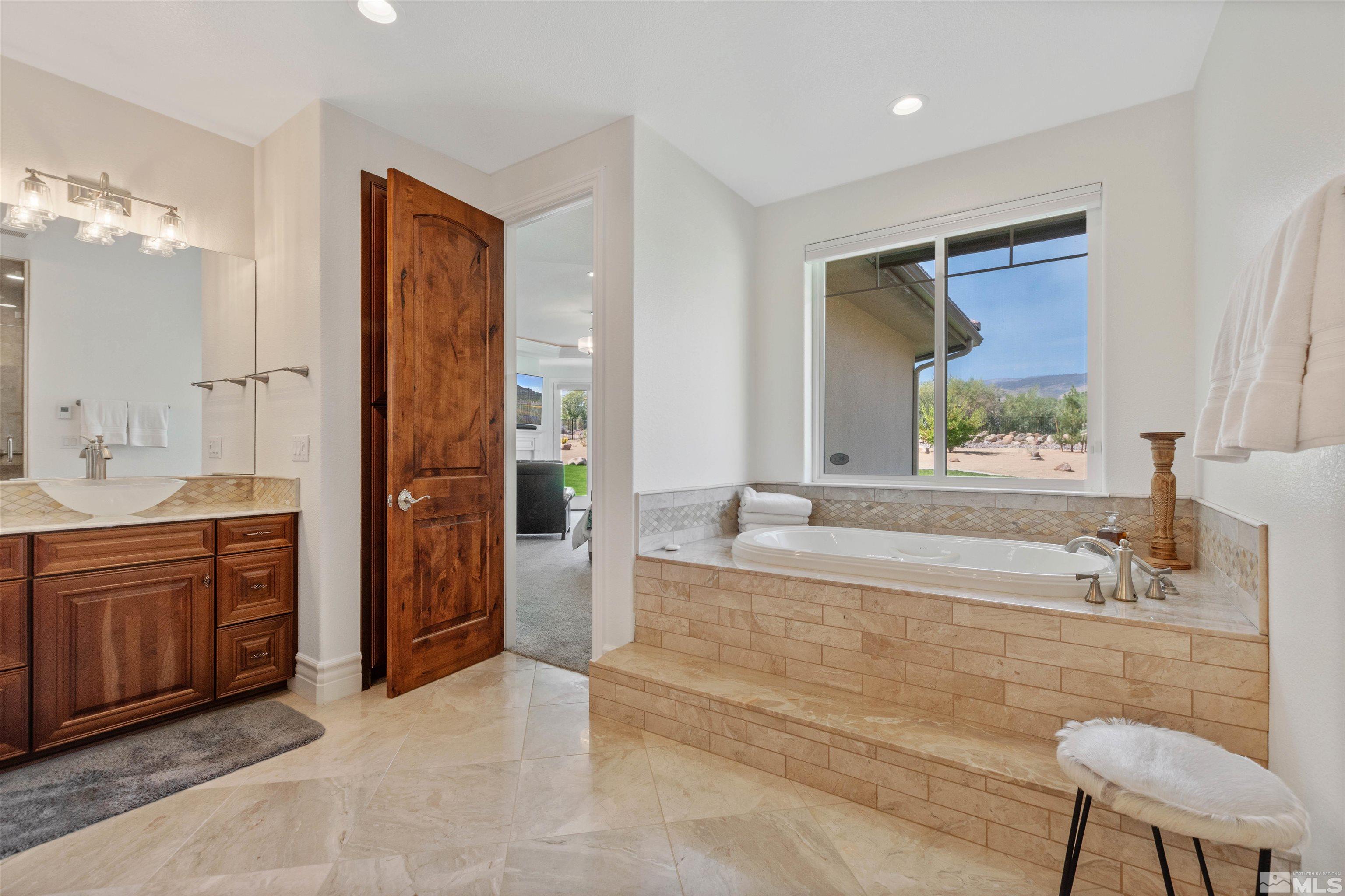 12825 Silver Wolf Road Reno, NV 89511 - Photo 23 of 34 a spacious bathroom with a tub sink and mirror