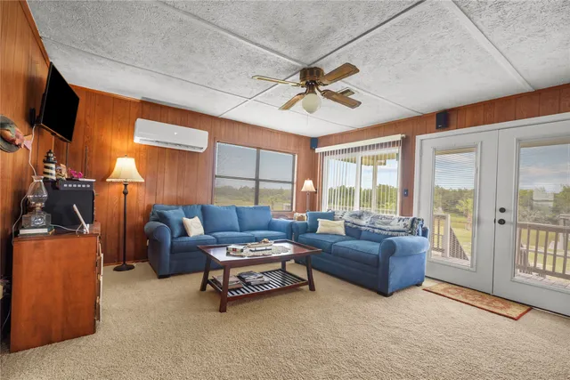 a living room with furniture a ceiling fan a flat screen tv and a window