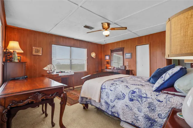 a bedroom with a bed and large windows