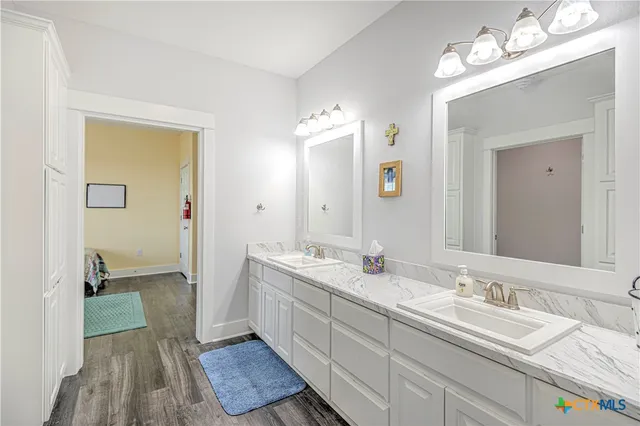 a bathroom with a granite countertop double vanity sink and a mirror