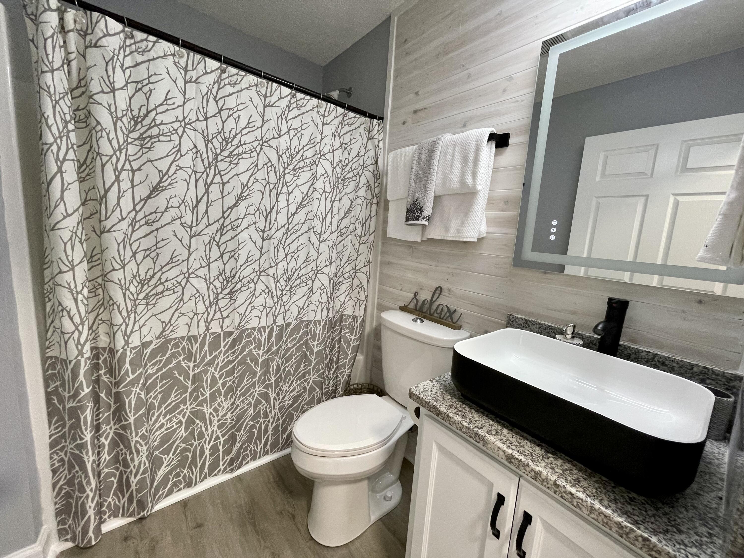 4694 Bobolink Way Crestview, FL 32539 - Photo 11 of 28 a bathroom with a granite countertop toilet sink and mirror